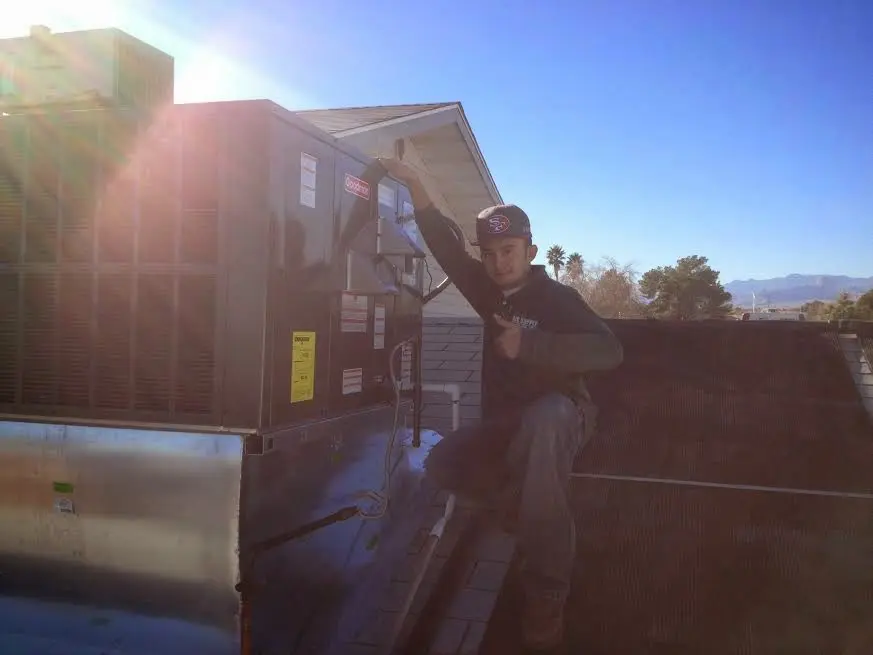 HVAC technician performing Boiler Repair on a rooftop unit in DuPont